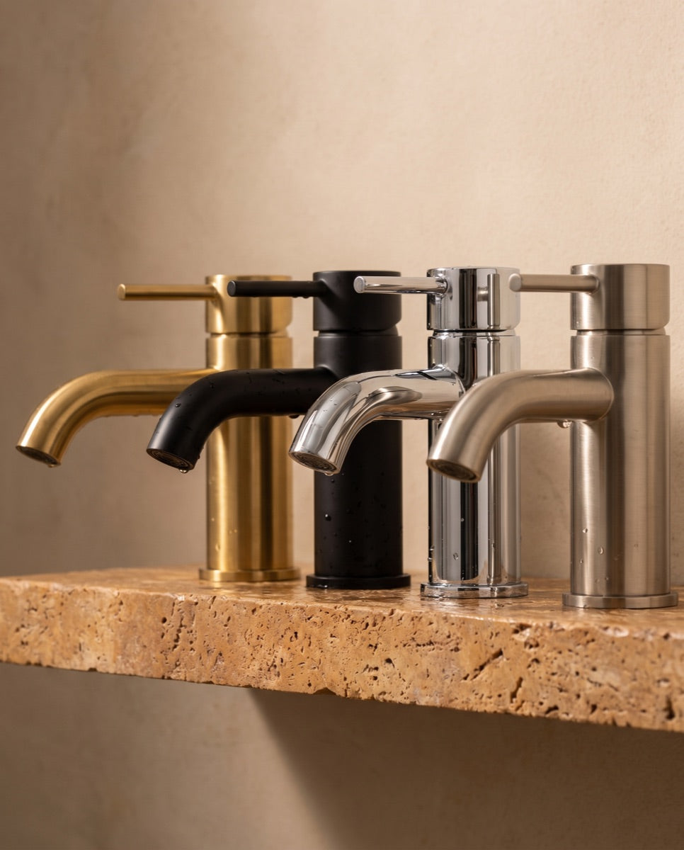 A detail of bathroom faucet spouts in brushed gold, matte black, chrome and brushed nickel finishes.