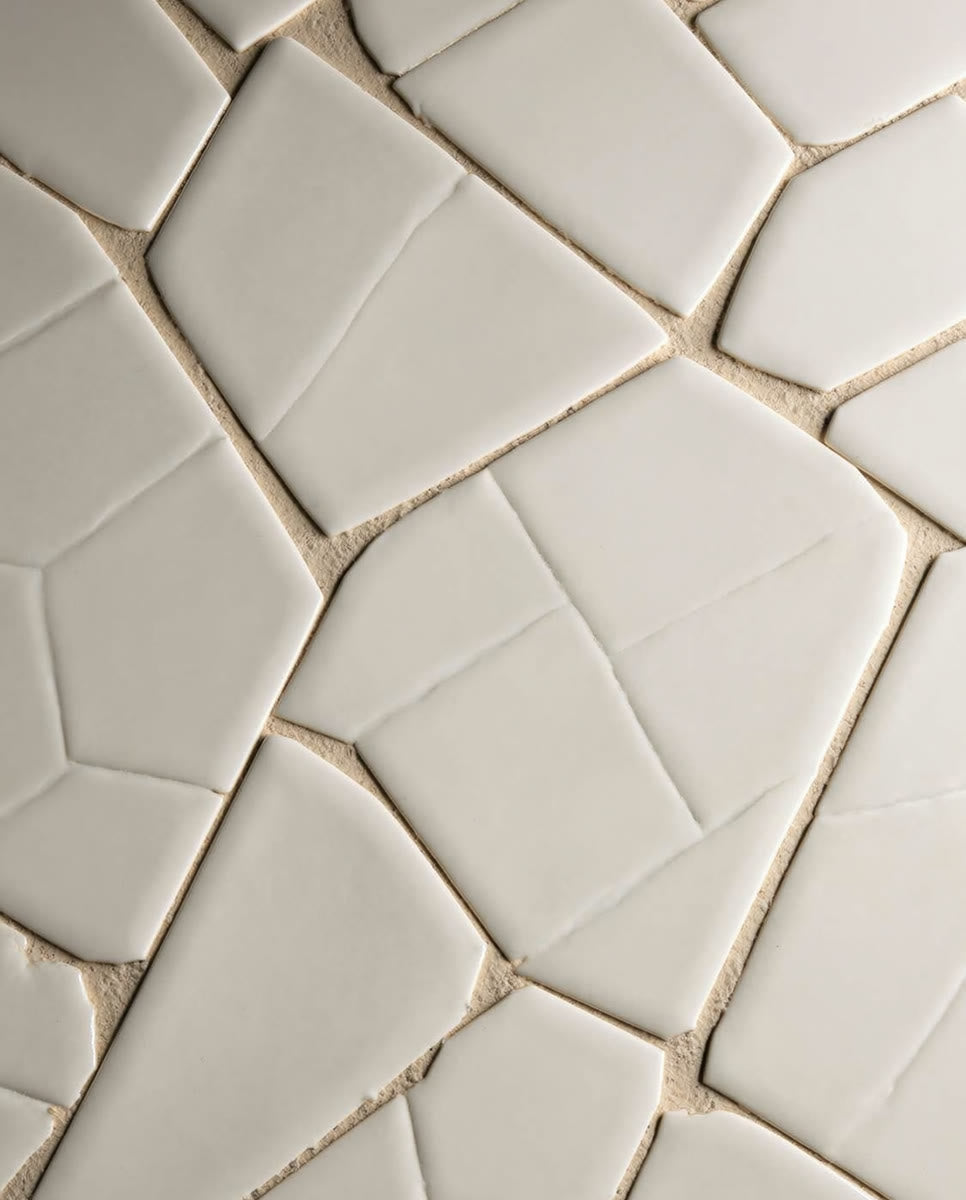 A close overhead detail of a marble-look basketweave mosaic floor with crisp grout lines and pale-gold veining.