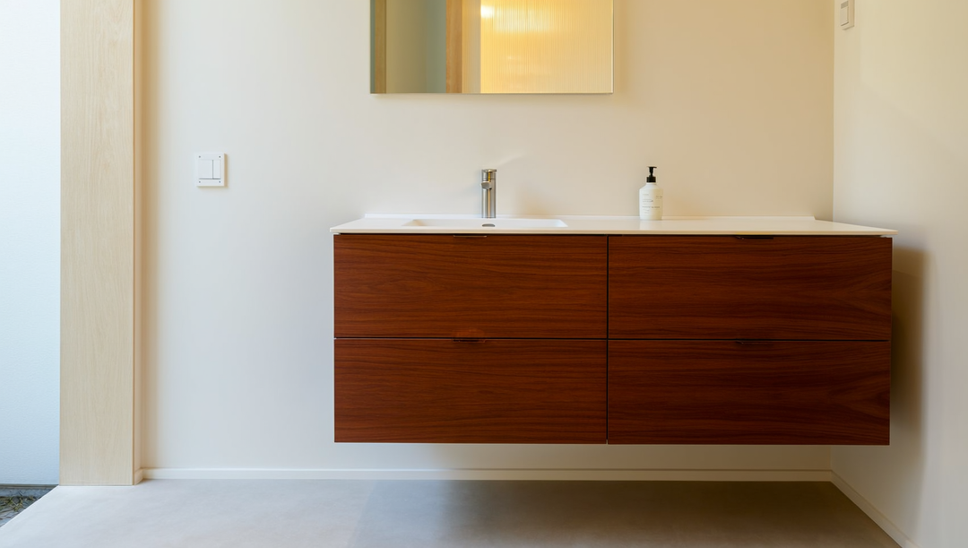 Wall-mounted floating bathroom vanity in a warm rosewood finish