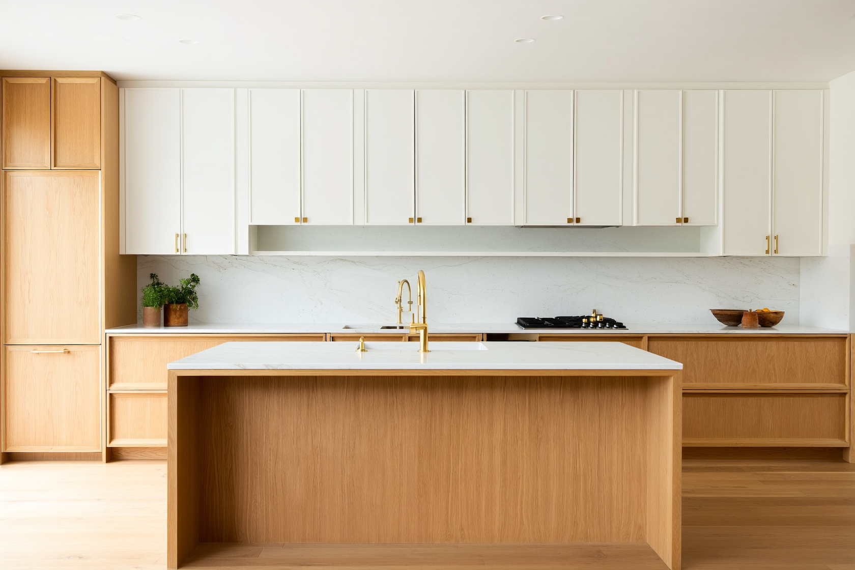 Bright white and wood kitchen with white upper cabinets, oak lower cabinets and island, marble backsplash, and brass har