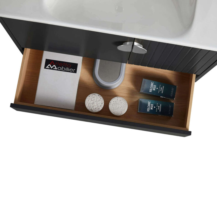 Open the drawer of the Venezian 30 inch Bathroom Vanity With Sink to reveal two round white textured items, a booklet, and two dark-labeled bottles, all neatly arranged around the sink plumbing.