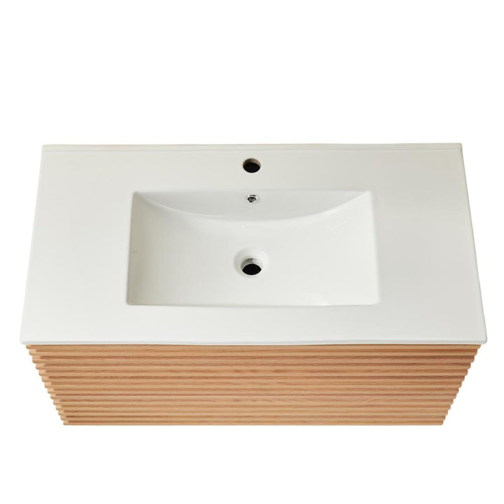 Rectangular white bathroom sink with a central faucet hole, set on a Linea 36 Inch Wall Mounted Bathroom Vanity featuring horizontal light wood slats. The top-down photo highlights its modern and minimalist design.