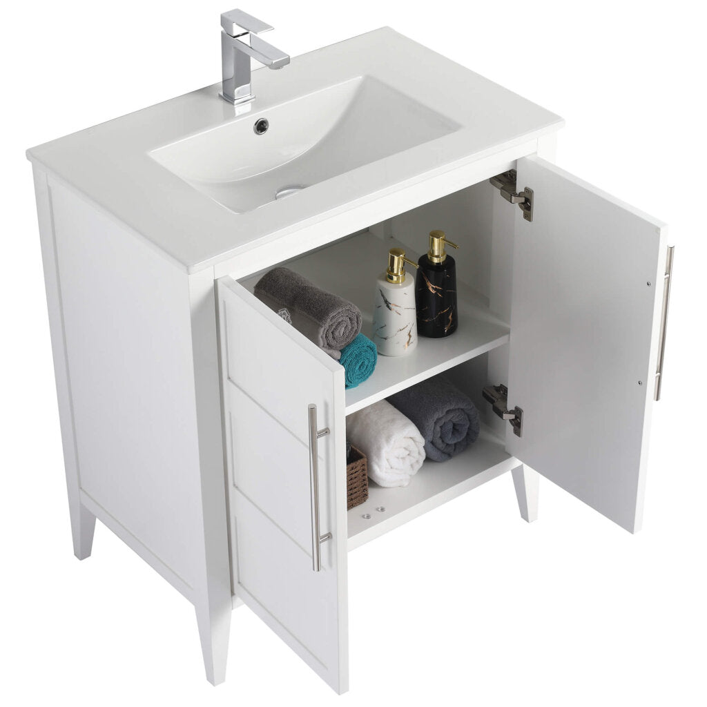 The Leafside 30 Inch Bathroom Vanity With Sink showcases a sleek rectangular sink and chrome faucet. Inside its cabinet doors, the shelves hold stacked towels, a decorative box, and two elegant bottles, blending style with functionality.