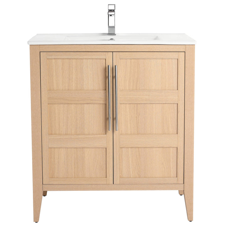 The Leafside 30 Inch Bathroom Vanity features a light oak finish with two cabinet doors and vertical metallic handles. It includes a white sink paired with a modern faucet, all in a wooden design.
