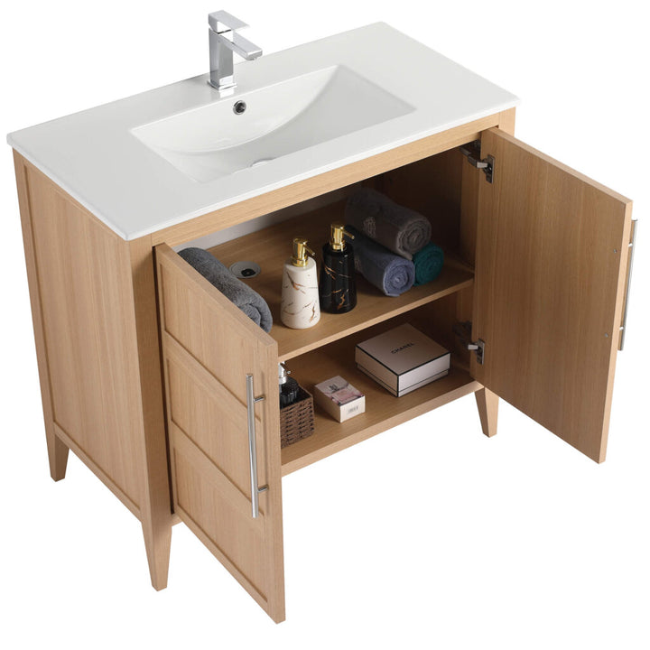 Introducing the Leafside 36 Inch Bathroom Vanity With Sink, featuring open wooden cabinet doors revealing neatly arranged toiletries and towels. The bright white sink is complemented by a sleek chrome faucet, while the interior holds rolled towels, bottles, a box, and a jar for your convenience.