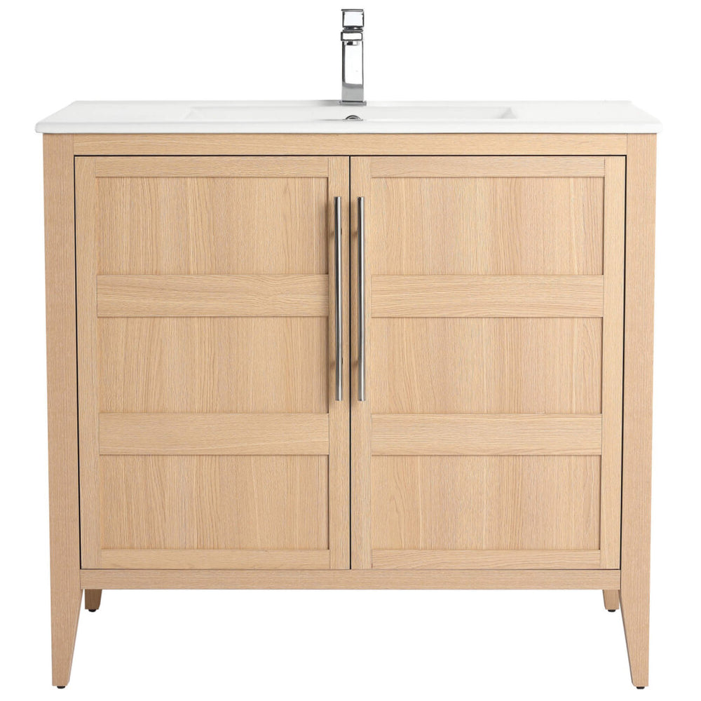 The Leafside 36 Inch Bathroom Vanity With Sink features a natural finish, double paneled doors, sleek vertical handles, a pristine white countertop, and a modern silver faucet, blending style and function for your bathroom oasis.