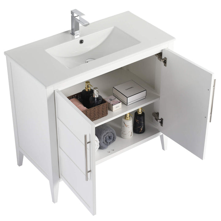 The Leafside 36 Inch Bathroom Vanity With Sink boasts an open cabinet displaying neatly arranged towels, a basket with bottles, and toiletries. Its sleek design is enhanced by the integrated sink and overhead faucet.