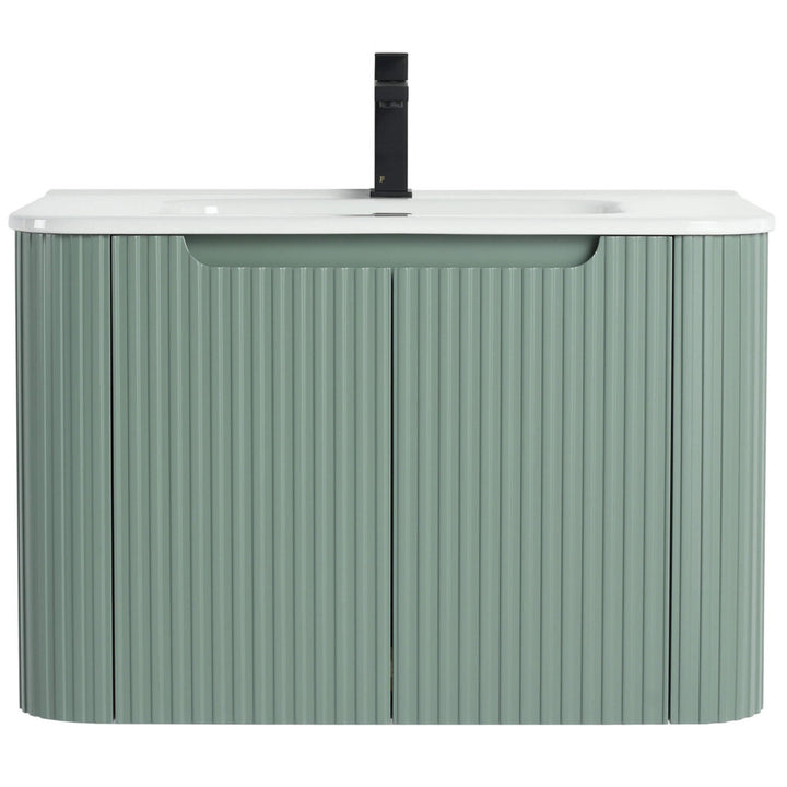 The Caskvalley 30 Inch Wall Mounted Bathroom Vanity With Sink offers a modern design featuring a sleek white countertop and integrated sink. Its base has a vertical ribbed pattern in muted green, harmonized by a centered black faucet for an elegant touch.
