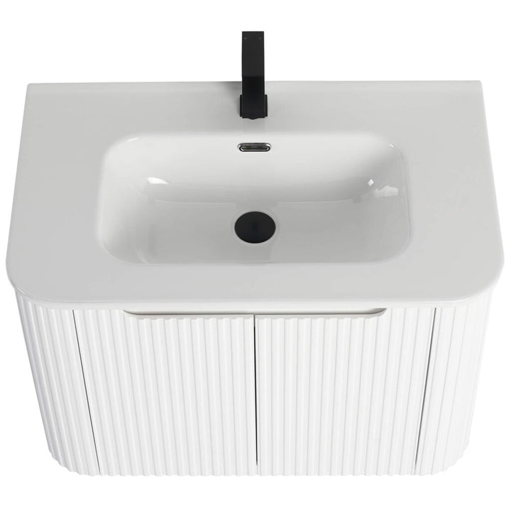 The Caskvalley 30 Inch Wall Mounted Bathroom Vanity With Sink showcases a modern white basin and sleek black faucet. Its rectangular sink has rounded edges and rests on a cabinet highlighted by vertical fluted detailing.