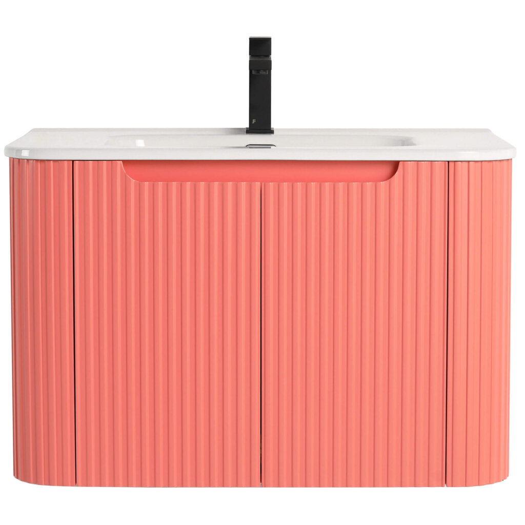 The Caskvalley 30 Inch Wall Mounted Bathroom Vanity boasts a ribbed coral pink cabinet and white countertop, paired with a single black faucet and integrated sink. Its handle-free design provides a sleek, minimalist look.