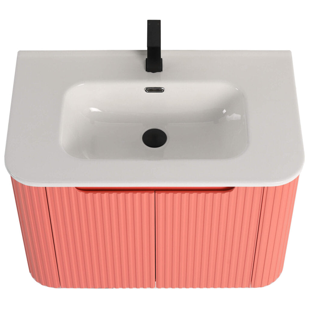 The Caskvalley 30 Inch Wall Mounted Bathroom Vanity With Sink boasts a modern rectangular basin and white countertop. It includes a cabinet with pink vertically-grooved doors for ample storage, complemented by a sleek black faucet to enhance its contemporary design.