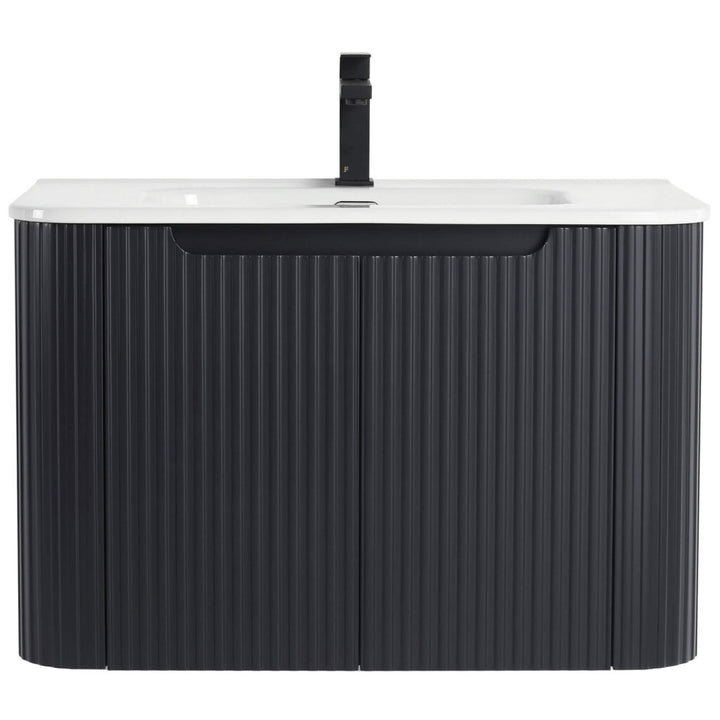 The Caskvalley 30 Inch Wall Mounted Bathroom Vanity With Sink showcases a modern look with its white countertop, black ridged cabinet doors, and a sleek dark faucet centered above the sink, reflecting contemporary minimalism.