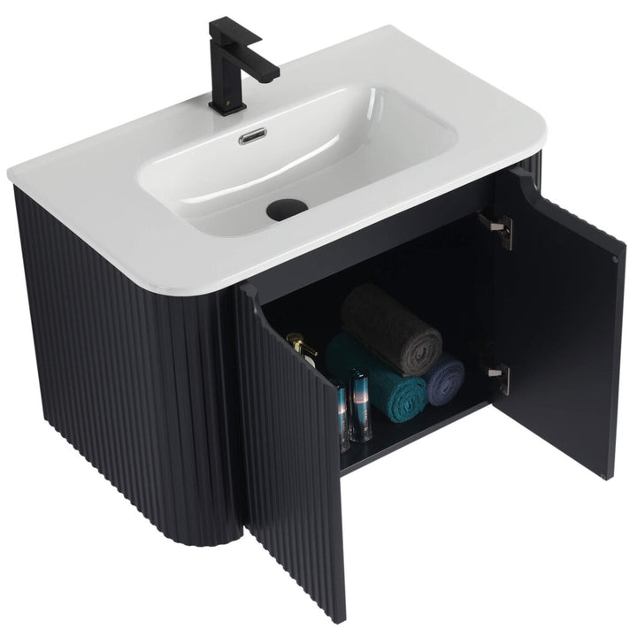 Explore the modern black fluted Caskvalley 30 Inch Wall Mounted Bathroom Vanity With Sink. It boasts a sleek white rectangular sink and a coordinated black faucet, while the open cabinet below stylishly showcases neatly organized towels and toiletries.