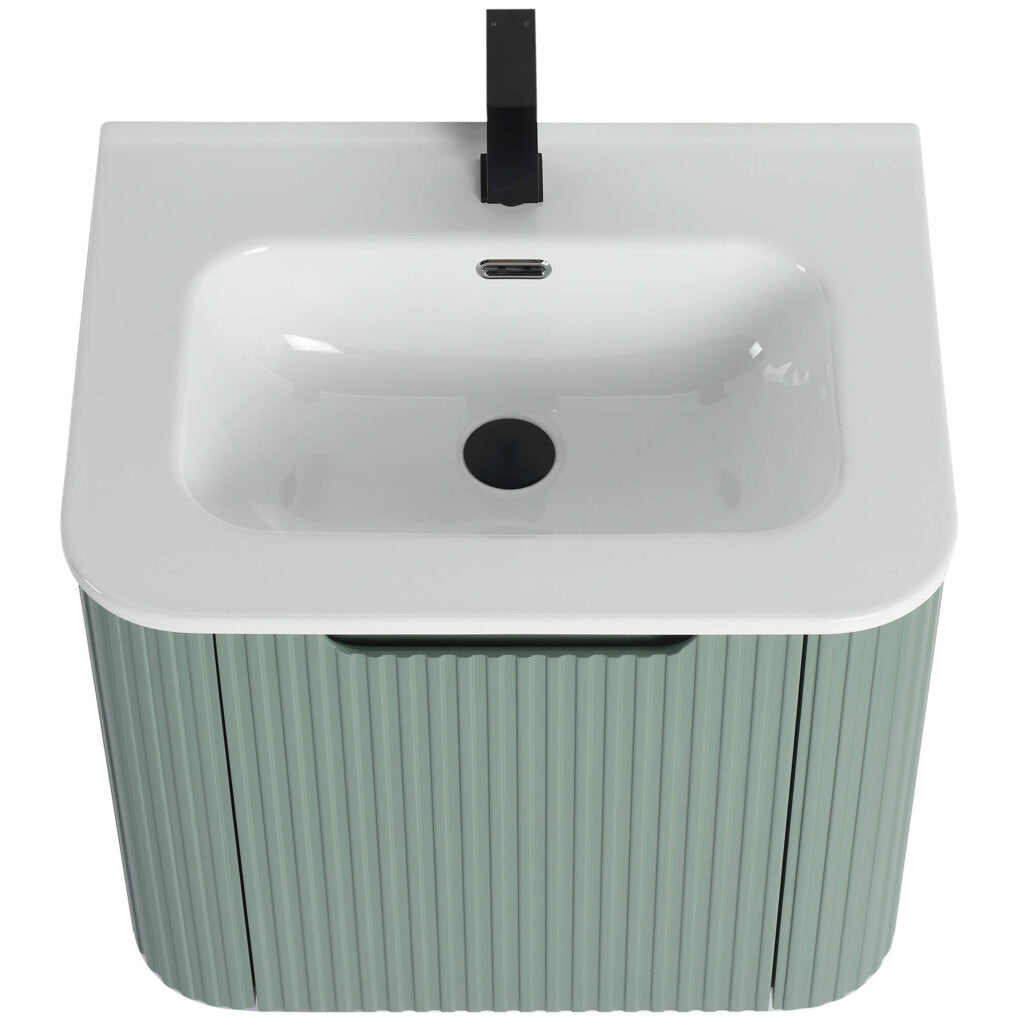 The Caskvalley 24 Inch Wall Mounted Bathroom Vanity features a modern white sink, textured light green cabinet, and sleek black faucet. Its minimalist design highlights a rectangular basin with rounded edges and a centrally positioned faucet.