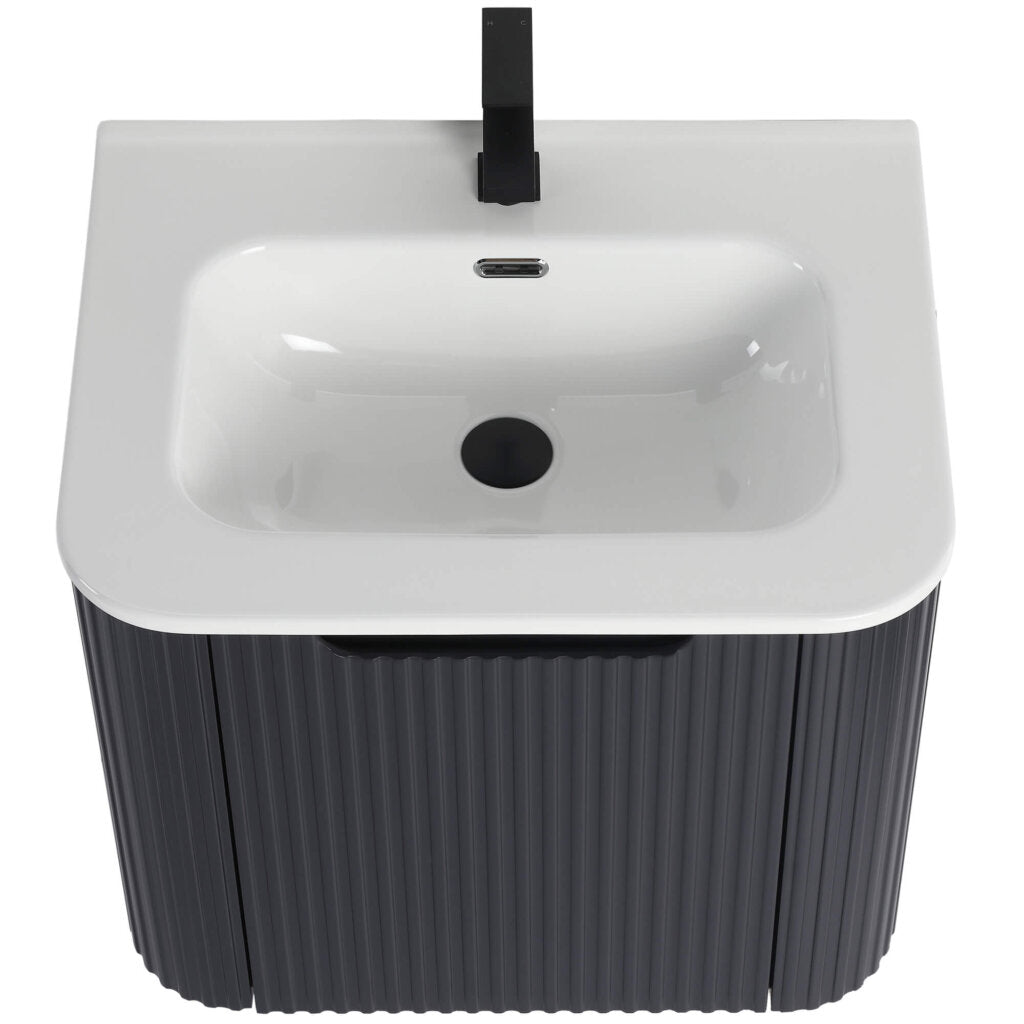 The Caskvalley 24 Inch Wall Mounted Bathroom Vanity With Sink boasts a modern white ceramic basin paired with a single black faucet atop a dark ribbed cabinet, featuring an overflow hole and central drain for seamless style and functionality.