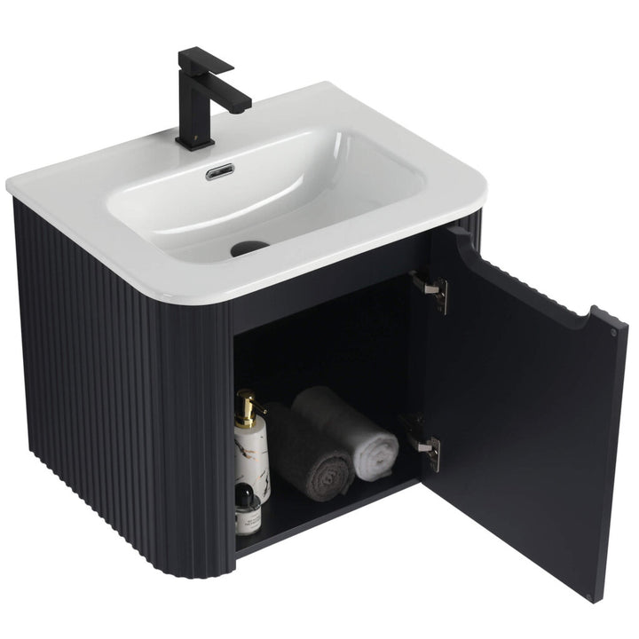 The Caskvalley 24 Inch Wall Mounted Bathroom Vanity With Sink flaunts a sleek black look, featuring a countertop sink and faucet. Inside the open cabinet door, youll find two rolled towels and bottles, while ribbed-textured sides add a touch of elegance.
