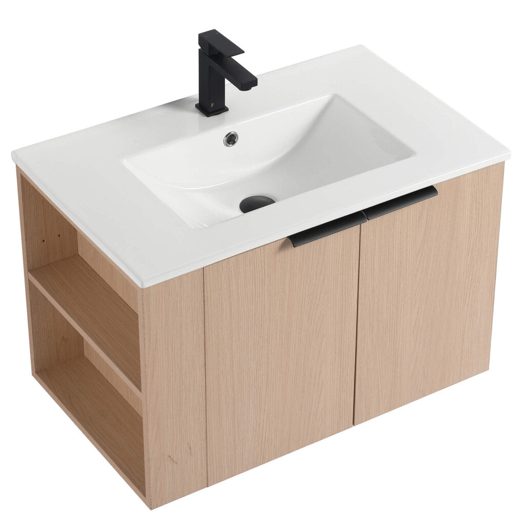 The Elmridge 30 Wall Mounted Bathroom Vanity combines a modern light wood finish with a sleek white rectangular sink and bold black faucet. It features two cabinet doors and side open shelving for plenty of storage.