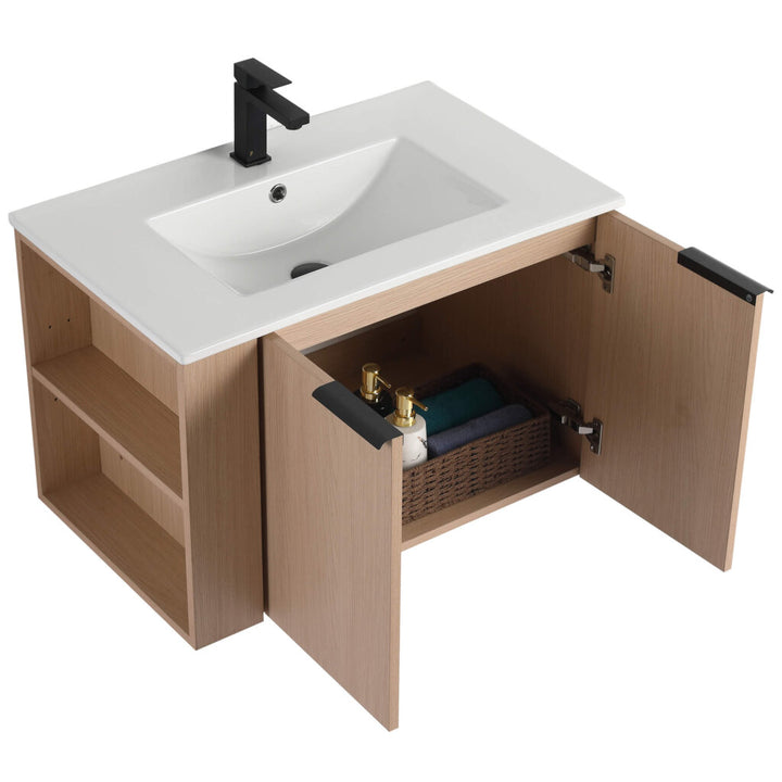 The Elmridge 30 Inch Wall Mounted Bathroom Vanity With Sink flaunts a modern light wood finish, includes a white sink and black faucet, and features open cabinet doors with a basket and bottles inside, plus side shelves for extra storage.