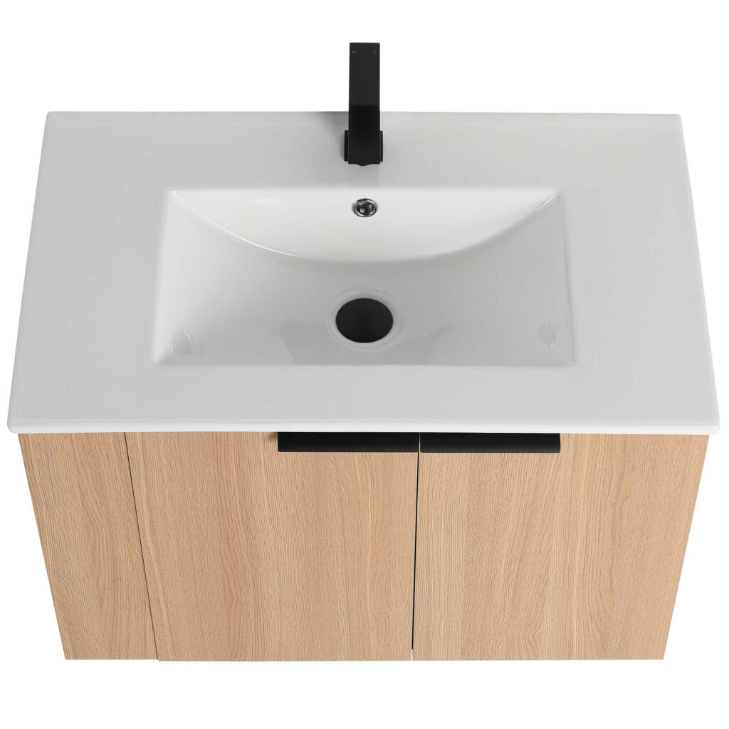 The Elmridge 30 Inch Wall Mounted Bathroom Vanity With Sink features a rectangular white ceramic sink with a black faucet on a light wood base. This modern design includes a central drain and faucet hole, providing an elegant and functional bathroom upgrade.