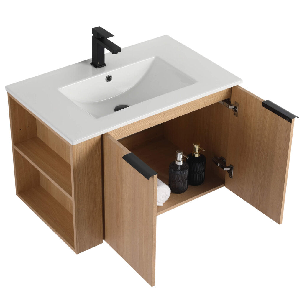 The Elmridge 30 Inch Wall Mounted Bathroom Vanity With Sink offers style and utility with a white sink, black faucet, two wooden cabinet doors for hidden storage, and side shelving for toiletries and towels.