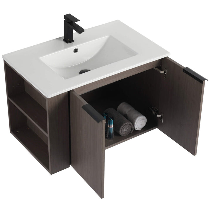 The Elmridge 30 Inch Wall Mounted Bathroom Vanity With Sink features a wooden finish, white rectangular sink, black faucet, open cabinets for towels and toiletries, and left-side shelves for extra storage. Its partially open doors add casual charm.