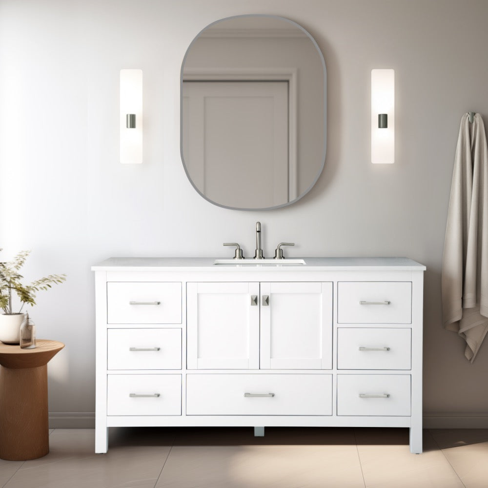 In a modern bathroom, the Vanea 60 Single Bathroom Vanity in White with a White Quartz Top, featuring six drawers and a central cabinet, is complemented by a curved rectangular mirror. Vertical sconces provide soft lighting while a towel on the right underscores the minimalist design.