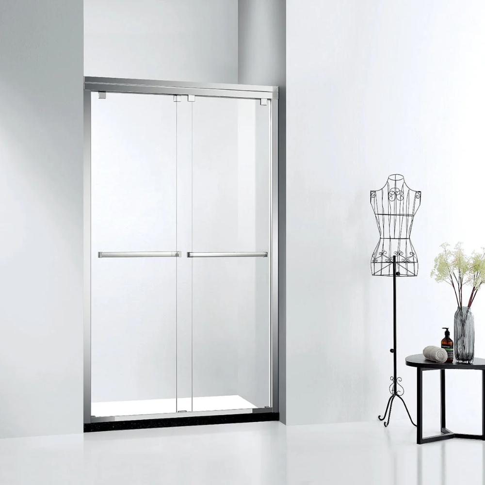 A modern bathroom features an ASD Cascade Shower Door – Bypass Sliding framed in silver, a black metal dress form, and a small table with a vase of flowers against a white wall.