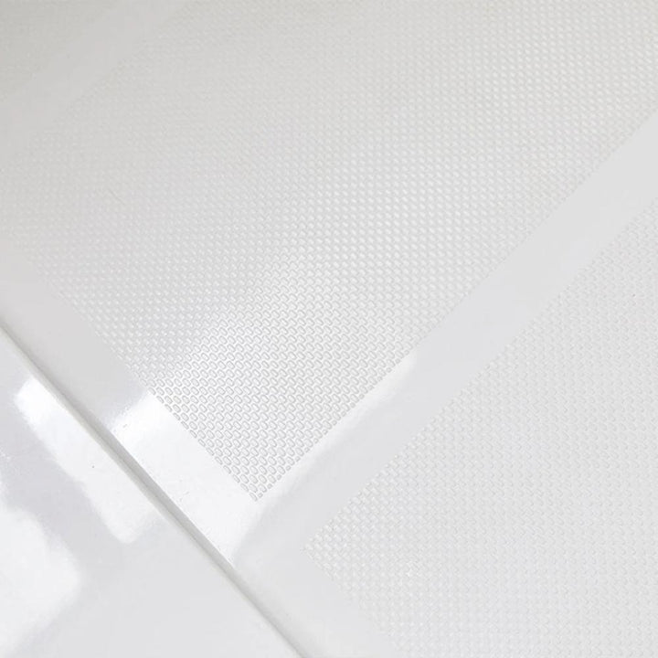 Close-up of the Bhavana Single Threshold Shower Base, white and textured, with a glossy transparent sheet partially covering it to highlight the contrast between matte and shiny surfaces.