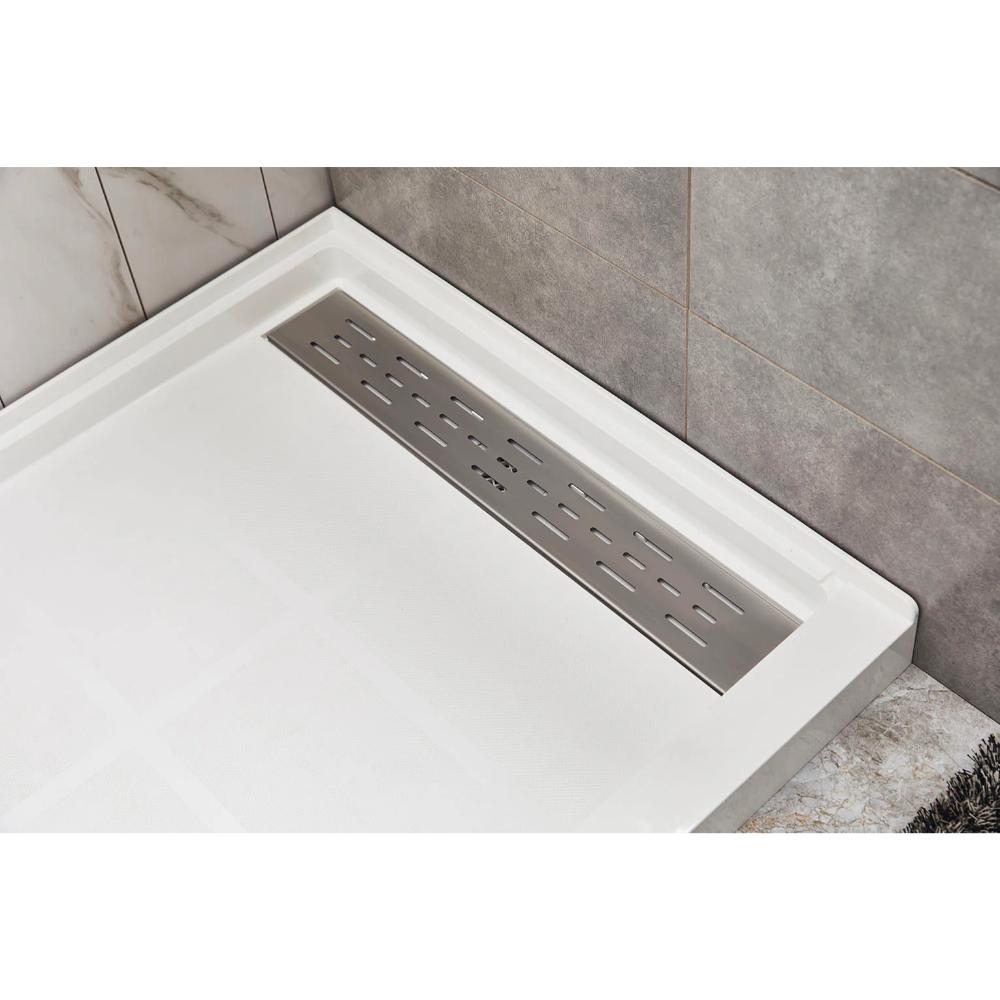 Close-up of a Bhavana Single Threshold Shower Base with large, light tiles and a rectangular stainless steel linear drain, framed by gray and marble-patterned wall tiles for a sleek, modern appearance.