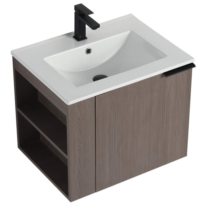 The Elmridge 24 Wall Mounted Bathroom Vanity includes a white ceramic sink and black faucet. Its contemporary wooden cabinet has an open shelf on the left and a door on the right, offering both style and functionality.