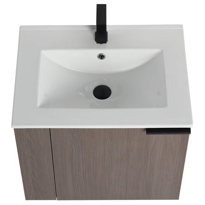 The Elmridge 24 Inch Wall Mounted Bathroom Vanity features a modern white rectangular basin with a black faucet, mounted on a wood-textured cabinet with a black handle, offering contemporary elegance through its minimalistic design.