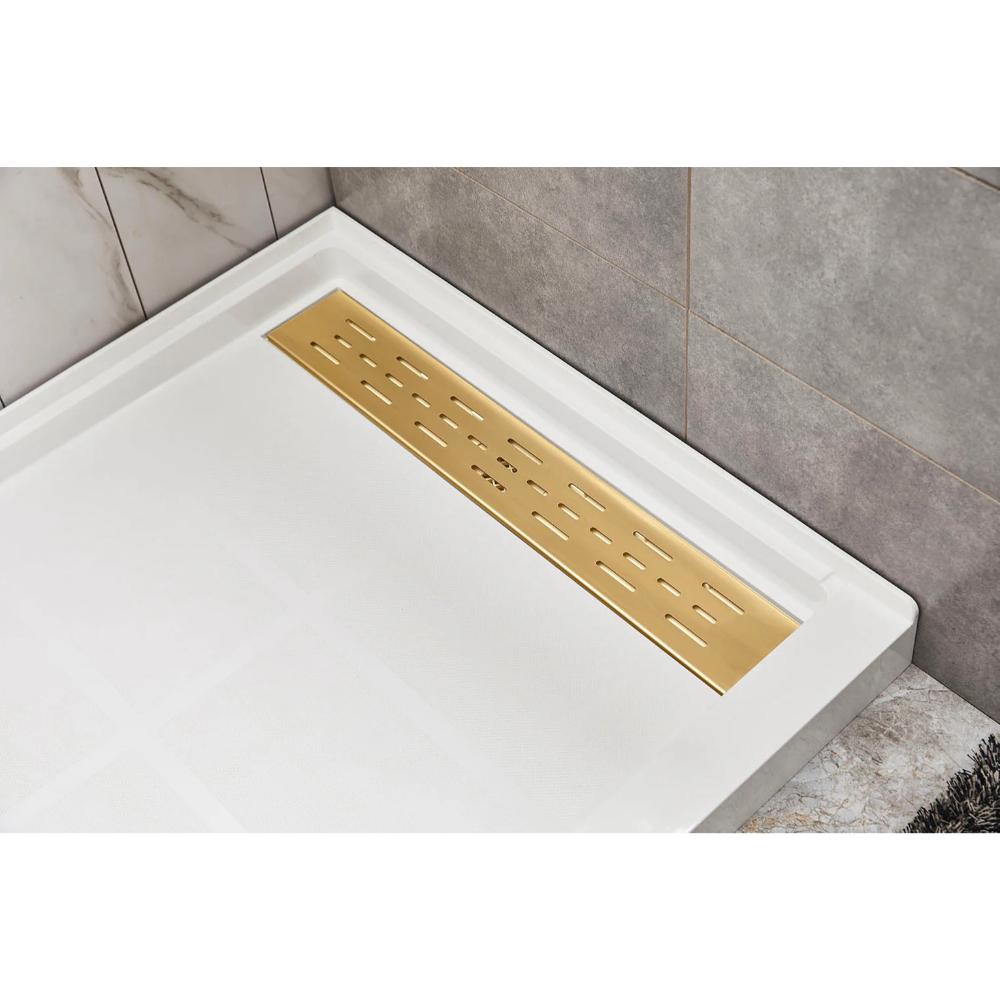 A modern shower floor showcases the Bhavana Single Threshold Shower Base and a rectangular gold-toned linear drain, set against white and gray corner tiles.
