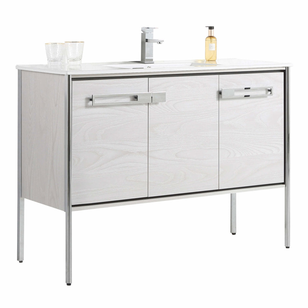 The Oakville 48 inch Modern Bathroom Vanity features a white finish, rectangular sink, chrome faucet, soap dispenser, two glasses, three cabinet doors, and stands on four slim metal legs for a sleek look.