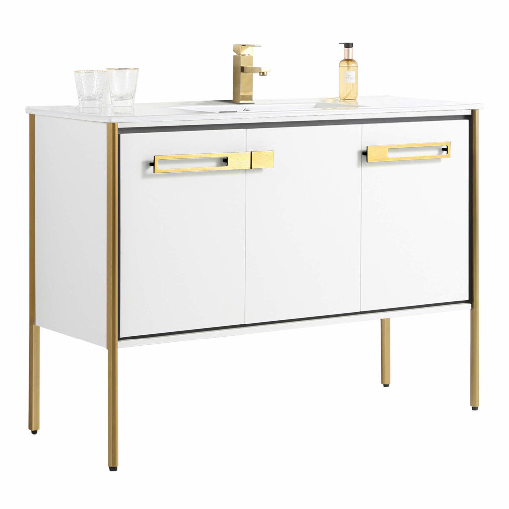 The Oakville 48 inch Modern Bathroom Vanity features white cabinets with gold handles and legs, a modern countertop with a gold faucet, two clear glasses, and a soap dispenser for a sleek, stylish bathroom update.