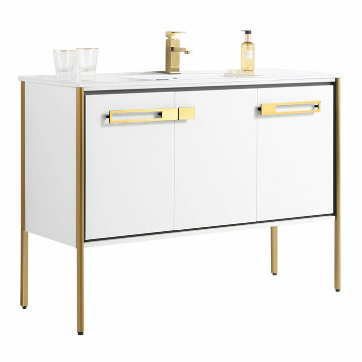 The Oakville 48 inch Modern Bathroom Vanity features white cabinets with gold handles and legs, a modern countertop with a gold faucet, two clear glasses, and a soap dispenser for a sleek, stylish bathroom update.
