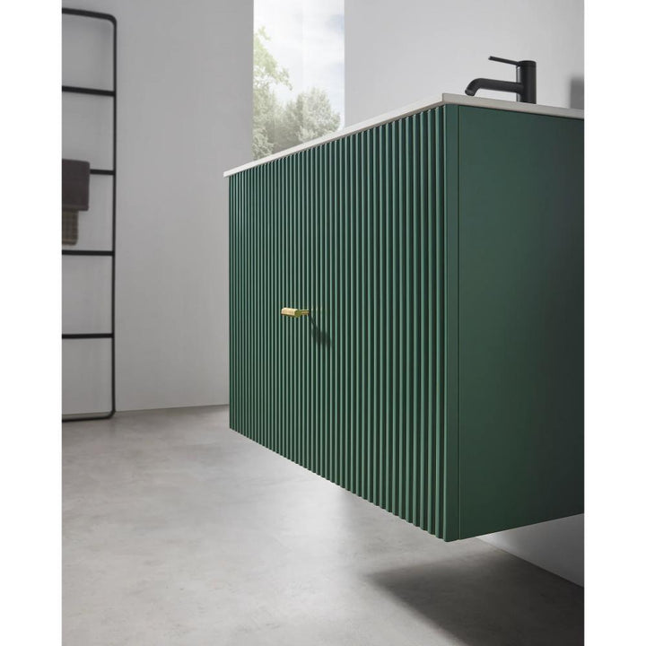 A modern bathroom features the Barcelona 30 Inch Wall Mount Bathroom Vanity in green with vertical grooves, a white countertop, and a black faucet. The minimalist space includes a window and a black towel rack in the background.