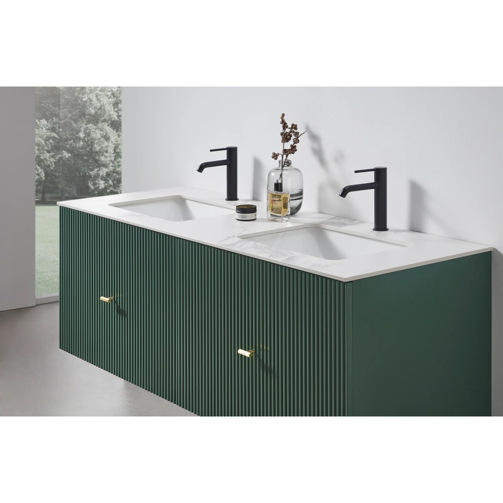 The Barcelona 60 Inch Wall Mount Double Bathroom Vanity With Top features dark green, vertically grooved drawers, a white countertop, two black faucets, and minimal decor. A window offers views of greenery that enhance the vanity’s modern style.