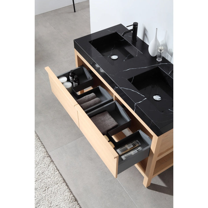 The Bibury 48 Inch Double Bathroom Vanity with Top features a black marble double sink, light wood cabinet, and three open drawers for towels and toiletries. Light gray tile flooring and a beige rug complete the modern look.