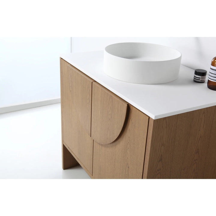 The Celle 36 Inch Bathroom Vanity With Vessel Sink offers a white countertop, modern round vessel sink, and rounded handles, with toiletries neatly arranged on the surface.