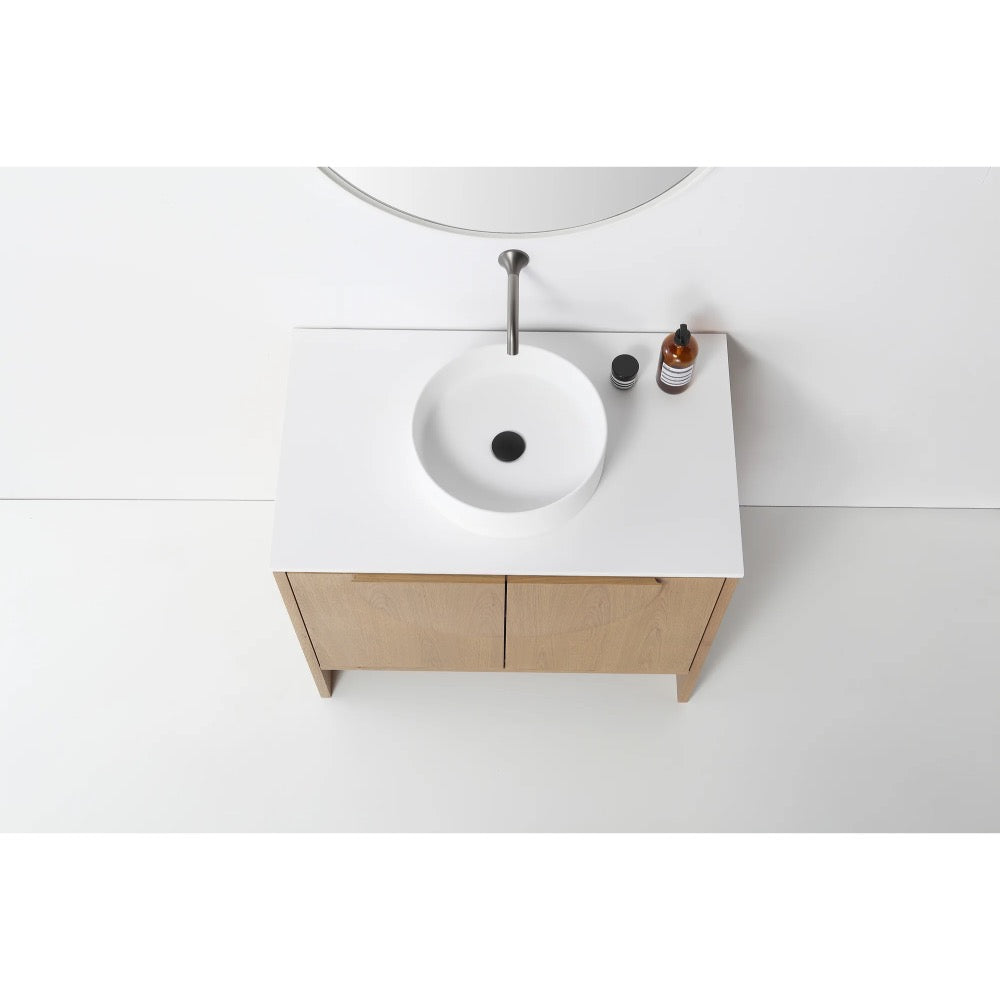 Overhead view of the Celle 36 Inch Bathroom Vanity With Vessel Sink, showcasing a round white sink, single faucet, soap dispenser, and small container on a white countertop with light wood cabinets.