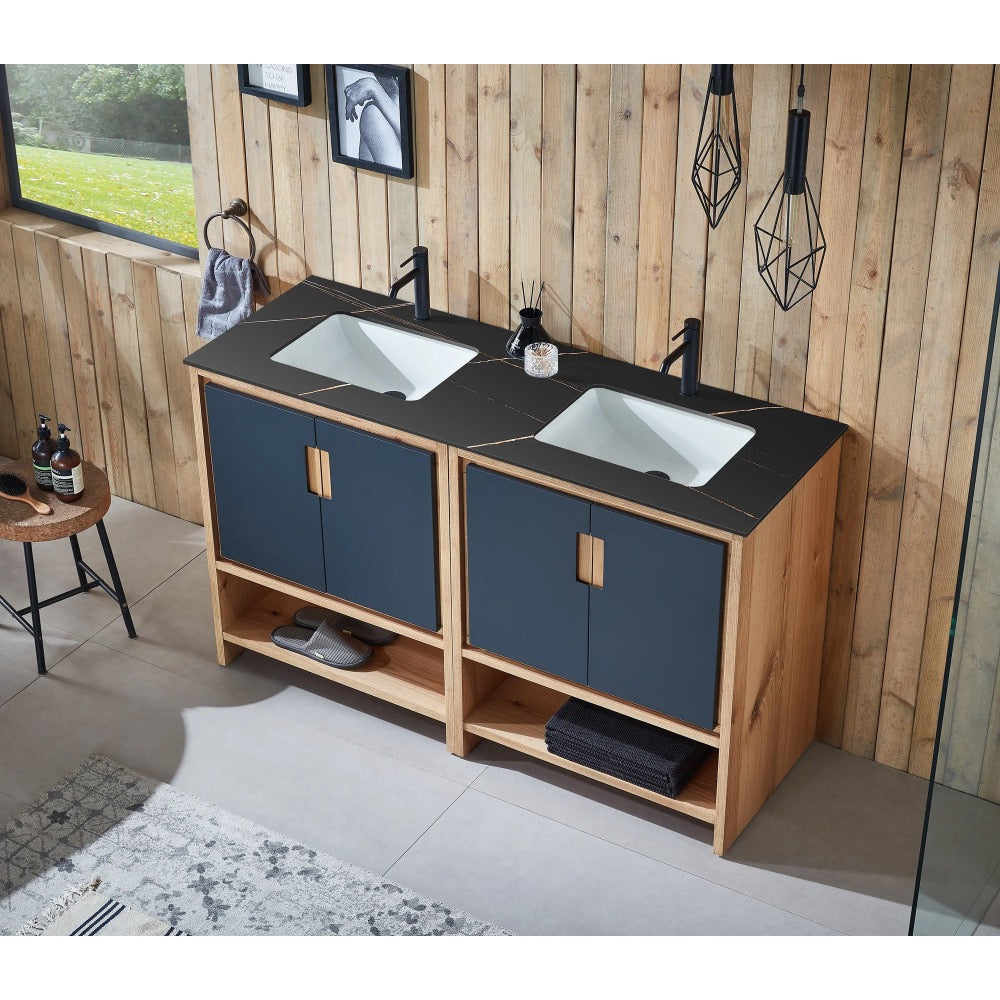 The Lyon 60 Inch Double Bathroom Vanity with Top features black faucets, blue and wood cabinets, and open lower shelves in a modern bathroom with wood-paneled walls, pendant lights, and large windows for natural light.
