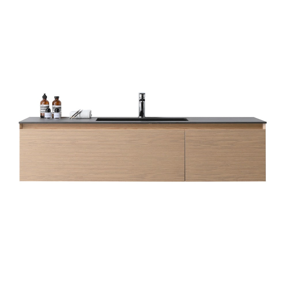 The Oslo 60 Inch Wall Mount Single Bathroom Vanity features a modern floating design with a light wood finish, black countertop, built-in sink, and faucet. Bottles and a folded towel rest neatly on the left side of the vanity.