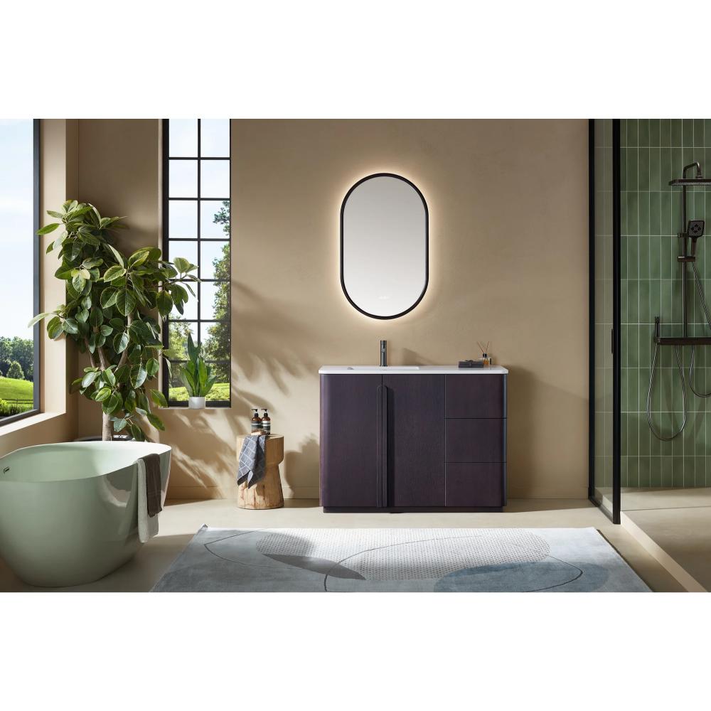 Modern bathroom featuring a Parma 48 Inch Bathroom Vanity With Top, a freestanding tub, oval backlit mirror, large window, green plant, and a glass-enclosed shower with green tile walls. Natural light fills the space.