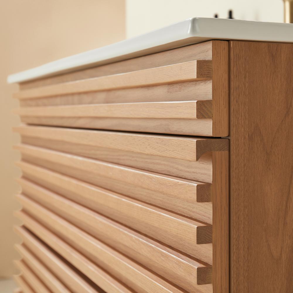 A close-up view of a Linea 36 Inch Wall Mounted Bathroom Vanity, featuring a wooden cabinet with horizontal slatted panels and a white countertop, highlighting the texture and grain of the wood.