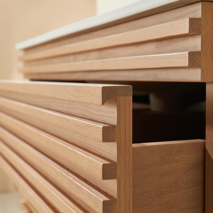 Close-up of a wooden dresser with horizontal slatted drawer fronts, inspired by the Linea 36 Inch Wall Mounted Bathroom Vanity. A partially open drawer reveals a dark interior and sleek, modern, minimalist design.
