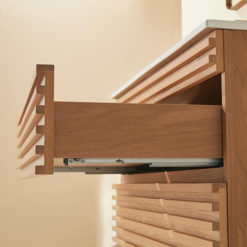 A close-up of the Linea 36 Inch Wall Mounted Bathroom Vanity with a partially open drawer reveals smooth wood grain and modern horizontal grooves, while warm lighting highlights its texture and craftsmanship.