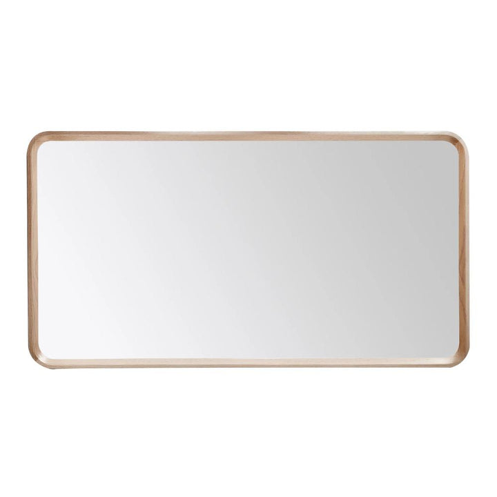 The Vela Mirrors wall mirror features a rectangular shape with rounded corners and a slim, light wooden frame, reflecting a blank white background.