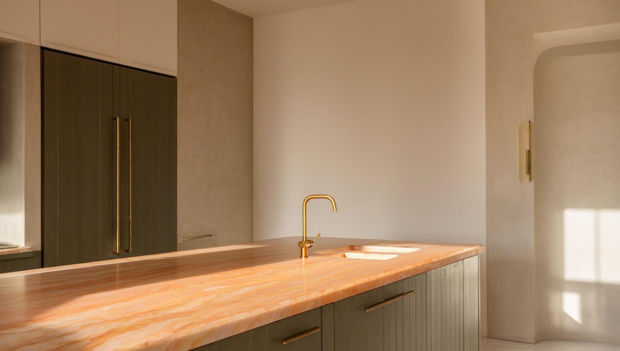 Warm veined quartz countertop over sage green cabinetry