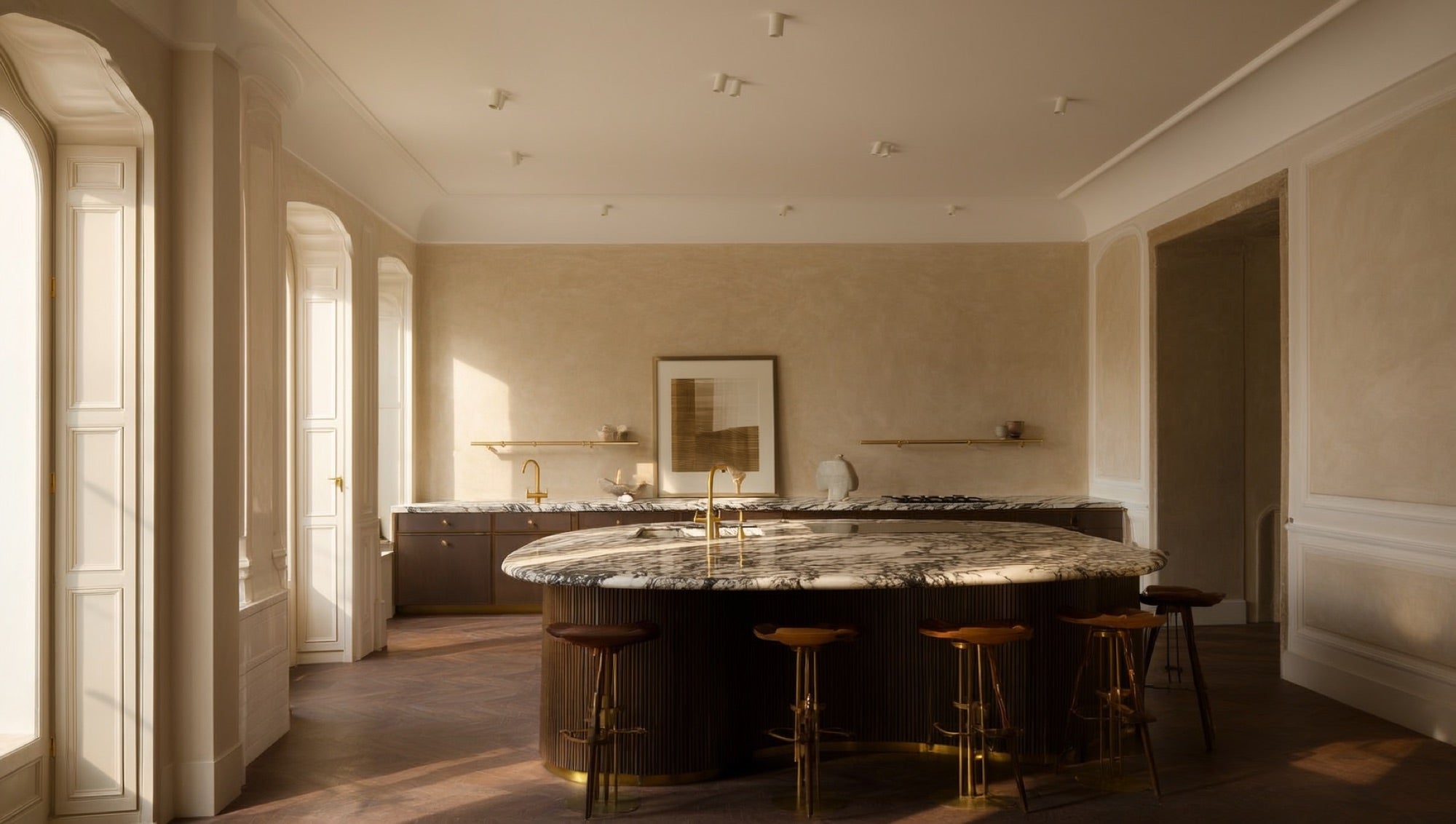 Deep-veined quartz island with brass fixtures and walnut stools