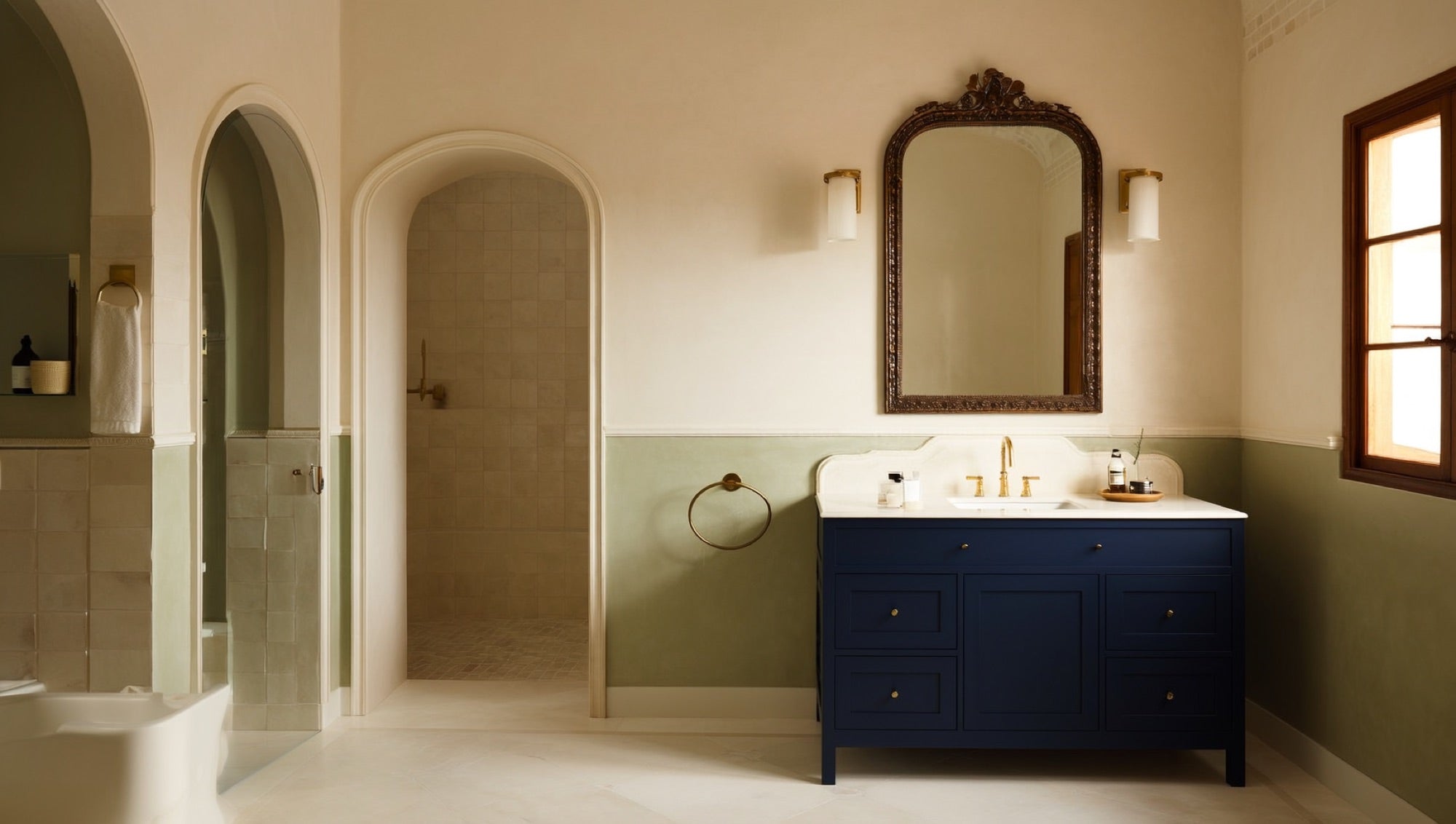 Navy transitional vanity with antique-brass mirror and sage green tile